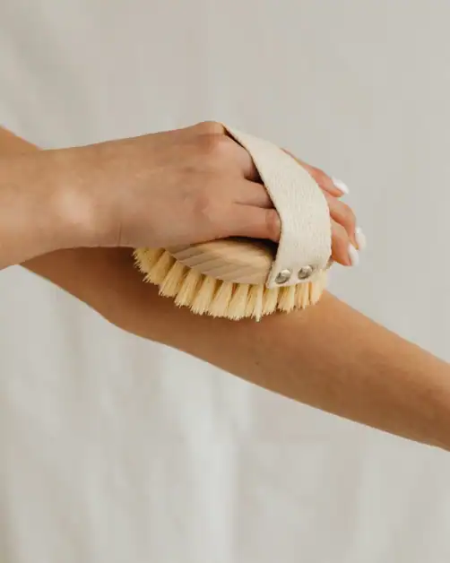 Woman dry brushing as a part of self-care routine